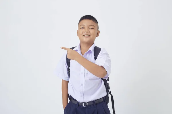 タイの学校の制服を着た若いアジア系のかわいい男の子がバックパックバッグを持って白い背景のバナーに本を書いています 学校に戻る — ストック写真