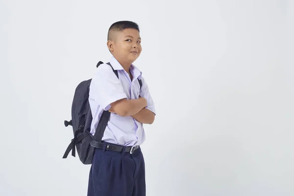 タイの学校の制服を着た若いアジア系のかわいい男の子がバックパックバッグを持って白い背景のバナーに本を書いています 学校に戻る — ストック写真