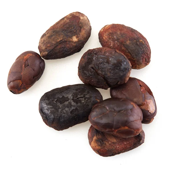 Yakın plan soyulmamış kakao çekirdeği beyaz arka planda izole edilmiş.