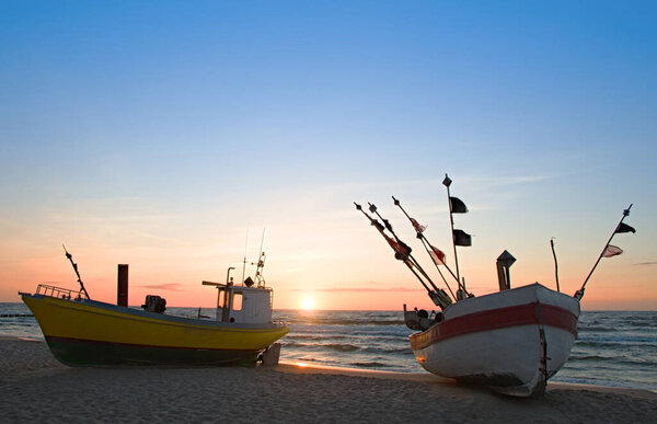 Fishing boat on the beach of the Polish Baltic coast near Rewal. Sunset