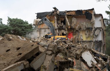 Eski binanın sökülme işlemleri devam ediyor. Kazıcı evi yıkıyor. Yeni gelişmeler için harap olmuş konutların tahrip edilmesi