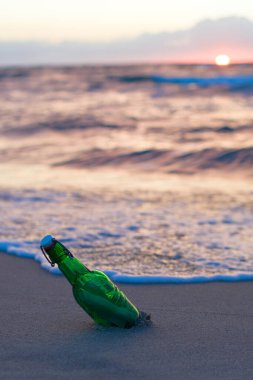 Şişedeki mesaj yumuşak dalgalara karşı kıyıya vurmuş. Rüya fikirler konsepti