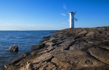 Polonya 'nın Baltık Denizi kıyısındaki bir limanı olan Swinoujscie' deki Seawall ve yel değirmeni Stawa Mlyny..