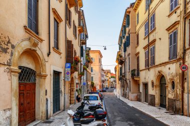 Verona, İtalya - 24 Ağustos 2014: İtalya 'nın tarihi merkezi Verona' da dar sokak manzarası. Sabah güneşinde evlerin cepheleri. Verona Avrupa 'nın popüler bir turizm beldesidir..