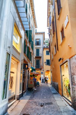 Verona, İtalya - 24 Ağustos 2014: İtalya 'nın tarihi merkezi Verona' da dar sokak manzarası. Sabah güneşinde evlerin cepheleri. Verona Avrupa 'nın popüler bir turizm beldesidir..