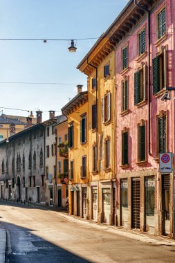 Verona, İtalya - 24 Ağustos 2014: İtalya 'nın tarihi merkezi Verona' da dar sokak manzarası. Sabah güneşinde evlerin cepheleri. Verona Avrupa 'nın popüler bir turizm beldesidir..
