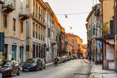 Verona, İtalya - 24 Ağustos 2014: İtalya 'nın tarihi merkezi Verona' da dar sokak manzarası. Sabah güneşinde evlerin cepheleri. Verona Avrupa 'nın popüler bir turizm beldesidir..