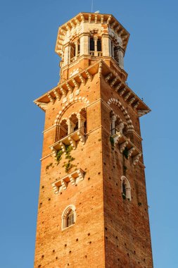Torre dei Lamberti Verona (İtalya) sabah güneşinde. Mavi gökyüzü arka plan üzerinde saat kulesi. Verona Avrupa'nın popüler bir turizm beldesidir.