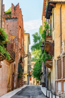 İtalya 'nın Verona şehrinin tarihi merkezinde dar bir sokak manzarası var. Sabah güneşinde evlerin cepheleri. Verona Avrupa 'nın popüler bir turizm beldesidir..