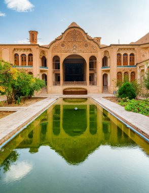 Bahçesi ve havuzu olan geleneksel İran avlusunun manzarası, Kashan, İran. Borujerdi Tarihi Evi suya yansıdı. Harika bir Pers mimarisi. Güzel dış görünüş..