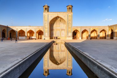 İran 'ın Shiraz kentindeki Vakil Camii' nin avlusundaki su deposuna yansıyan kuzey Iwan 'ın muhteşem manzarası. Müslüman mekanı Orta Doğu 'nun popüler bir turistik merkezi..