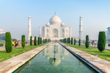 Hindistan 'ın Agra kentindeki Taj Mahal' de. Beyaz mermer mozole yapay havuza yansıdı. Tac Mahal Güney Asya 'nın popüler bir turistik merkezidir..