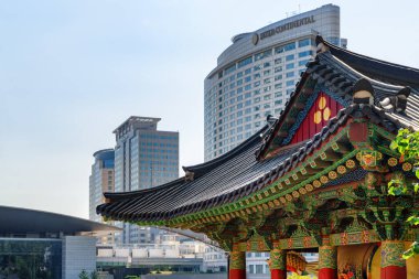 Seul, Güney Kore - 15 Ekim 2017 Bongeunsa Tapınağı 'nın renkli geleneksel Kore fayansları ve Gangnam Bölgesi' ndeki modern binalar. Bongeunsa Tapınağı Asya 'nın popüler bir turistik merkezidir..