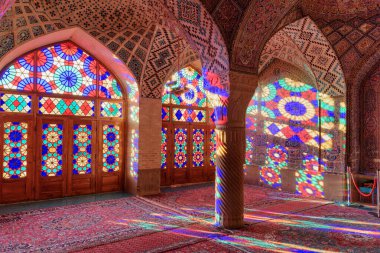 Şiraz, İran - 31 Ekim 2018: Pembe Cami 'deki Nasir el-Mülk Camii' nin duvarları ve zeminindeki vitray camlarından yansıtılan sabah güneşinin muhteşem manzarası (Pembe Cami Camii)).