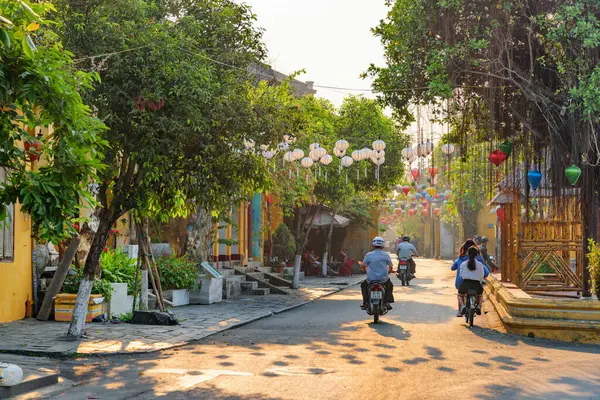 Hoi An (Hoian), Vietnam - 12 Nisan 2018: Gün doğumunda renkli ipek fenerlerle süslenmiş rahat caddenin manzarası. Hoi An Antik Kasabasının geleneksel sarı evleri.