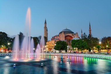 Sultanahmet Meydanı 'ndaki Çeşme ve İstanbul, Türkiye' deki Ayasofya 'nın gece manzarası. Sultanahmet Meydanı İstanbul 'un popüler bir turizm merkezi..