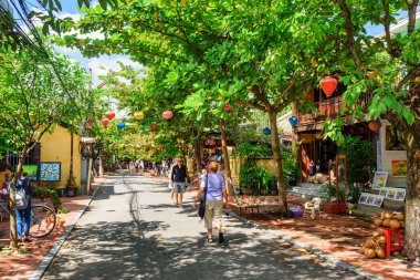 Hoi An (Hoian), Vietnam - 10 Kasım 2015: Hoi An Antik Kasabası 'nda renkli ipek fenerlerle süslenmiş inanılmaz yeşil bir cadde.