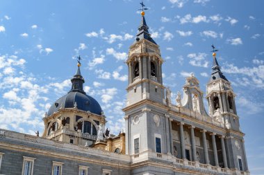 Madrid, İspanya yaz aylarında beyaz bulutlar ile mavi gökyüzü arka plan üzerinde Saint Mary Katedrali La Almudena Kraliyet yan görünümü. Madrid Avrupa'nın popüler bir turizm beldesidir.