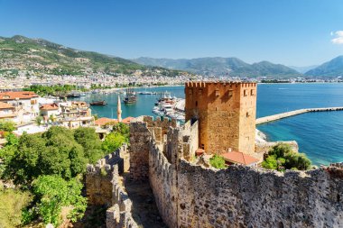 Türkiye 'deki Alanya Kalesi' nin surlarından Kizil Kule 'nin (Kızıl Kule) muhteşem manzarası. Akdeniz arka planda görülebilir. Sekizgen kırmızı tuğla kule popüler bir turistik merkezdir.
