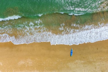 Kum plajının ve beyaz ibikli dalgaların havadan görünüşü. İnanılmaz zümrüt suyu. 