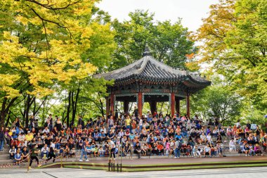 Seul, Güney Kore - 8 Ekim 2017: Turistler Namsan Dağı Parkı 'ndaki Palgakjeong Pavyonu' nun merdivenlerinde oturuyorlar. Seul Asya 'nın popüler bir turistik beldesidir..