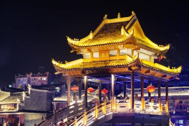 Fenghuang, Çin - 23 Eylül 2017: Phoenix Antik Kentinde geleneksel Çin mimarisinin unsurları ile muhteşem bir köprü gece görüşü. Fenghuang, Asya 'nın popüler bir turizm merkezidir..