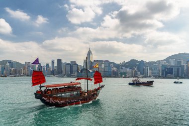 Hong Kong - 20 Ekim 2017 Victoria limanından geçen geleneksel Çin ahşap yelkenli gemisi. Hong Kong Adası silueti. İnanılmaz bir şehir manzarası.