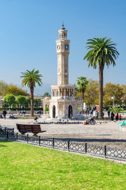 İzmir, Türkiye - 26 Ekim 2021: Konak Meydanı 'nın ortasındaki İzmir Saat Kulesi manzarası. Turistler ve halk dinleniyor ve meydanda yürüyorlar. Kule liman şehrinin simgesidir..