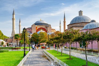 Yeşil bahçelerin arasındaki Ayasofya manzarası harika. Turistler ve halk dinleniyor ve manzaralı şehir parkı boyunca yürüyorlar..