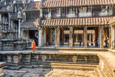 Siem Reap, Kamboçya - 4 Mayıs 2015: Angkor Wat antik tapınak kompleksinin avlusunda yürüyen Budist keşiş. Amazing Angkor Wat turistlerin ve hacıların popüler bir mekanıdır..