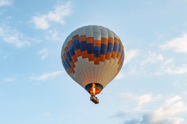 Güneş doğarken mavi gökyüzü arka planında renkli sıcak hava balonunun yakın görüntüsü. Balon Goreme Tarihi Ulusal Parkı üzerinde uçuyor, Kapadokya, Türkiye. Kapadokya popüler bir turizm merkezidir..
