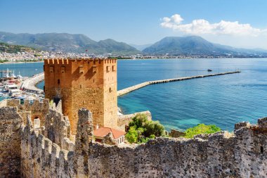 Türkiye 'deki Alanya Kalesi' nin surlarından Kizil Kule 'nin (Kızıl Kule) muhteşem manzarası. Akdeniz arka planda görülebilir. Sekizgen kırmızı tuğla kule popüler bir turistik merkezdir.