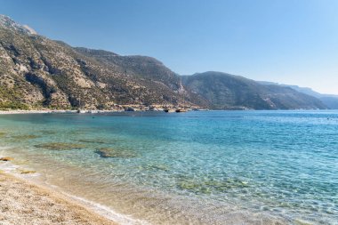 Türkiye 'nin Oludeniz Sahili' nden Akdeniz 'in harika berrak sularının manzarası. Manzaralı dağlar arka planda görünür. Oludeniz, Türkiye 'de popüler bir turizm merkezi..