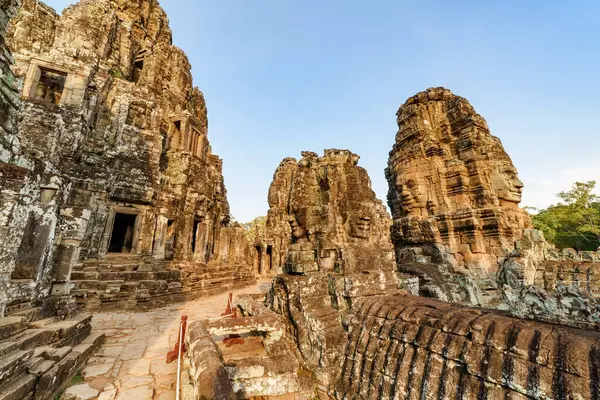 Akşam güneşinde Angkor Thom 'daki antik Bayon tapınağının gizemli kalıntıları. Muhteşem Angkor Thom Siem Reap, Kamboçya 'daki yağmur ormanlarının arasına yuva yaptı..