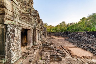 Akşam güneşinde Angkor Thom 'daki antik Bayon tapınağının gizemli kalıntıları. Muhteşem Angkor Thom Siem Reap, Kamboçya 'daki yağmur ormanlarının arasına yuva yaptı..