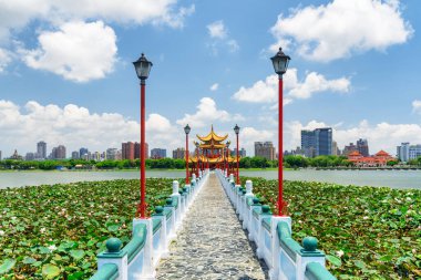 Awesome view of bridge leading to Wuliting at Lotus Lake in Kaohsiung, Taiwan. The traditional Chinese red pavilion with golden roof is a popular tourist attraction of Asia. clipart