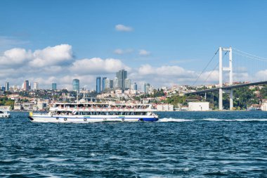 Turist teknesi Boğaz 'ı geçiyor. Avrupa 'yı Asya' ya bağlayan Boğaziçi Köprüsü 'nün (15 Temmuz Şehitler Köprüsü) muhteşem manzarası. İnanılmaz İstanbul silüeti.