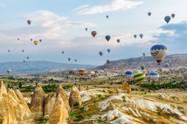 Kapadokya, Türkiye - 22 Eylül 2021: Goreme Tarih Ulusal Parkı üzerinde uçan renkli sıcak hava balonlarının muhteşem manzarası. Kapadokya 'nın muhteşem manzarası, Türkiye.