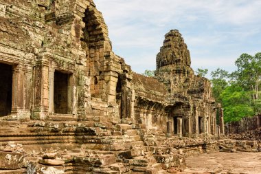 Angkor Thom 'daki antik Bayon tapınağının gizemli kalıntıları. Muhteşem Angkor Thom Siem Reap, Kamboçya 'daki yağmur ormanlarının arasına yerleşmiş. Enigmatic Angkor Thom popüler bir turistik ilgi odağı..