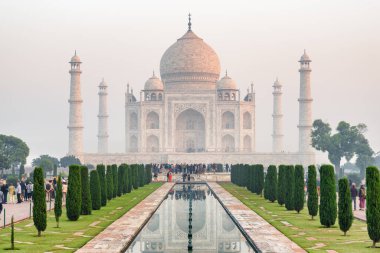 Hindistan 'ın Agra kentindeki Taj Mahal' de. Beyaz mermer mozole yapay havuza yansıdı. Tac Mahal Güney Asya 'nın popüler bir turistik merkezidir..