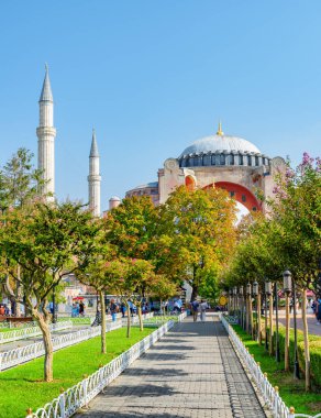 Yeşil bahçelerin arasındaki Ayasofya manzarası harika. Turistler ve halk dinleniyor ve manzaralı şehir parkı boyunca yürüyorlar..