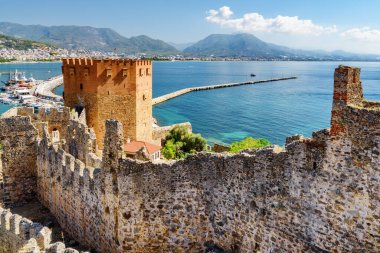 Türkiye 'deki Alanya Kalesi' nin surlarından Kizil Kule 'nin (Kızıl Kule) muhteşem manzarası. Akdeniz arka planda görülebilir. Sekizgen kırmızı tuğla kule popüler bir turistik merkezdir.