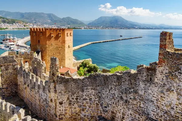 Türkiye 'deki Alanya Kalesi' nin surlarından Kizil Kule 'nin (Kızıl Kule) muhteşem manzarası. Akdeniz arka planda görülebilir. Sekizgen kırmızı tuğla kule popüler bir turistik merkezdir.