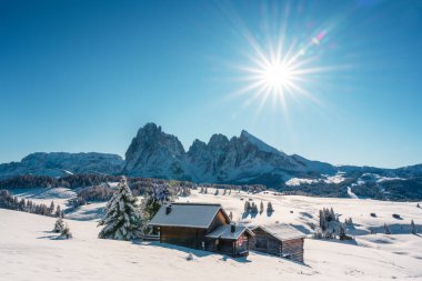 Gün doğumunda Alpe di Siusi otlağında küçük ahşap kulübe olan resimli manzara. Seiser Alm, Dolomitler, İtalya. Karlı tepeler turuncu tarla kuşu ve Sassolungo ve Langkofel dağları grubu