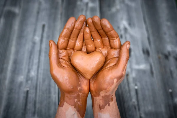 stock image Heart made of potters clay in the hands of a master potter. Love concept