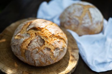 Geleneksel mayalanmış mayalı ekmek. Köy ahşap bir masada derisi pişmiş. Sağlıklı yemek fotoğrafçılığı