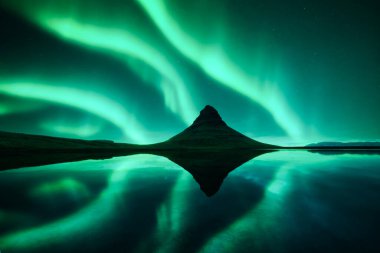 Aurora borealis kuzey ışıkları Kirkjufell dağ volkano üzerinde. Ünlü Kirkjufell Şelalesi, İzlanda yakınlarında inanılmaz bir gece sahnesi. Peyzaj fotoğrafçılığı