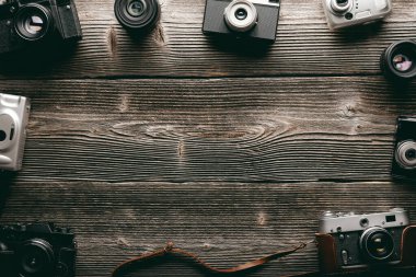 Photography concept background with different old vintage film photo cameras on grunge wooden table. Empty place for your text