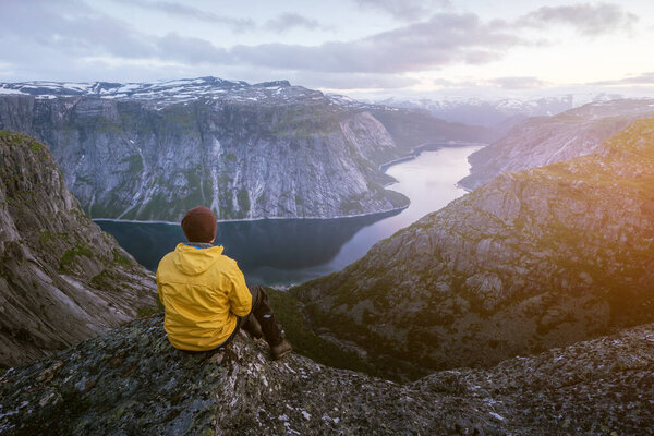Alone tourist on Trolltunga rock - most spectacular and famous scenic cliff in Norway. Landscape photography