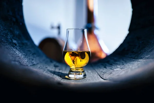 古いオーク樽の中のウイスキーのグラス 背景に銅アラミック 伝統的なアルコール蒸留所のコンセプト — ストック写真